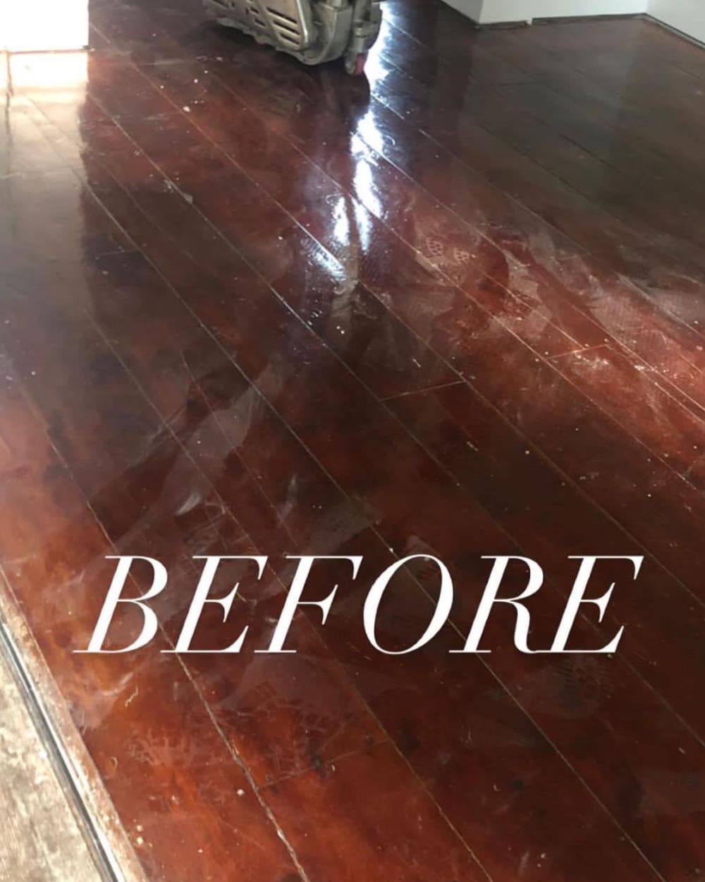 Before: worn hardwood floor being sanded down